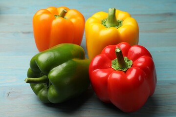Fresh colorful bell peppers on blue wooden table, closeup