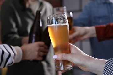 Friends having refreshing beer at home, closeup