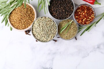 Different aromatic spices on white marble table, flat lay. Space for text