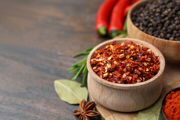Different aromatic spices on wooden table, closeup. Space for text