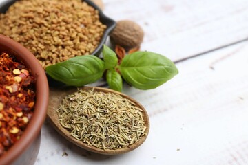 Different aromatic spices on white wooden table, closeup