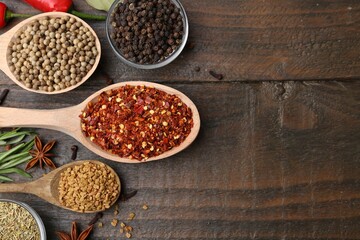 Different aromatic spices on wooden table, flat lay. Space for text