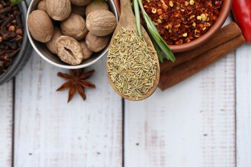 Different aromatic spices on white wooden table, flat lay. Space for text