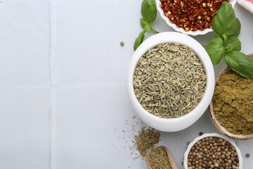 Different aromatic spices on white tiled table, flat lay. Space for text