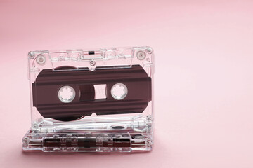 Audio cassettes with magnetic tapes on pink background, closeup. Space for text