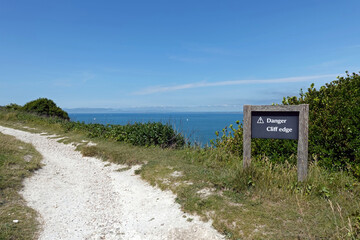 danger cliff edge sign on a coastal path warning of the dangers