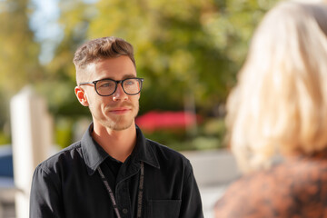 Employee listening attentively to resident outdoors, visible empathy and presence, respectful distance.