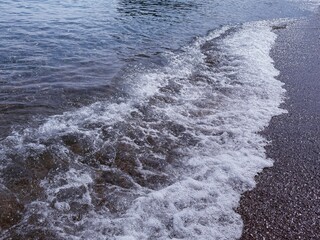 Sea waves foam on the beach.