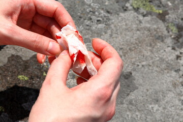 Hand with blood stained paper. Close up and isolated.
