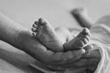 Mom's arms hug the baby. the legs of a newborn. the heels, the fingers of a baby, a child. Childbirth, maternity capital, artificial insemination, IVF, mortgage, family, love. High quality photo