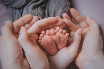 Mom's arms hug the baby. the legs of a newborn. the heels, the fingers of a baby, a child. Childbirth, maternity capital, artificial insemination, IVF, mortgage, family, love. High quality photo