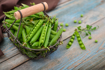 Pods of green peas in a metal basket
