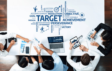 A top-down view of a business team analyzing performance metrics and strategies to achieve targets....