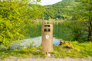 A trash can next to a trail on the shores of Lake Lugano, Switzerland