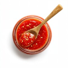 A close-up overhead shot of a jar filled with a bright red tomato sauce and a wooden spoon