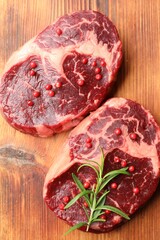 Pieces of raw beef meat and spices on wooden table, top view