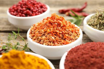 Different aromatic spices on wooden table, closeup