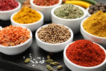 Different aromatic spices in bowls on table, closeup