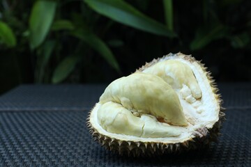 Fresh ripe durian on wicker table outdoors, closeup. Space for text