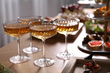 Buffet menu. Glasses of sparkling wine and tasty appetizers on table, closeup