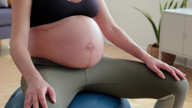 Pregnant woman doing exercises on fitness ball