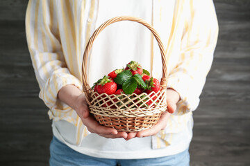 Woman with delicious ripe strawberries indoors, closeup
