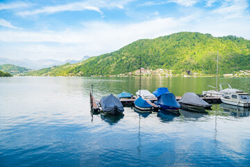 View of boats moored on Lake Lugano, village of Caslano. Switzerland