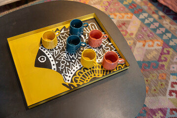 London, UK, 15 May 2025,  Shop Liberty.  A yellow tray with a stylized fish design holding colorful...