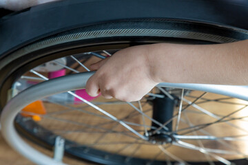 Top view of the arm of a child in a wheelchair. The concept of mobility problems.