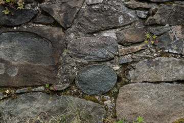 The stone wall of the old fortress of Gvara. The background is a stone wall