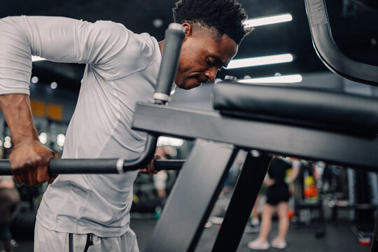 Determined athlete performing bodyweight dips on parallel bars in gym