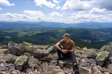 A man looks around on the top of a mountain.