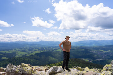 A tourist stands on the top of a mountain.