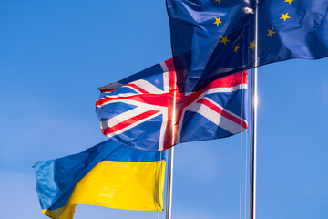Flags of Ukraine, Great Britain and the European Union on flagpoles.
