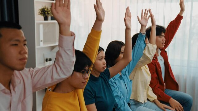 Group of interviewee candidate in colorful casual wearing line up for vacancy interview sitting on the chair. Intern raise hand. Job opportunity recruitment for HR agency and vacancy concept. Synergic