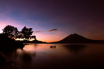 Starry night over Lake Atitl&aacute;n, Guatemala. Long exposure captures stars, volcanoes and colorful village lights reflecting on calm water, evoking peace, wonder, and adventure under the vast sky.