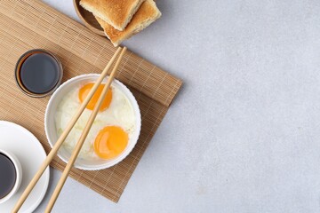 Traditional asian breakfast with half-boiled eggs, soy sauce, chopsticks, coffee and toasted bread...