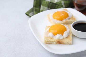 Traditional asian breakfast with tasty kaya toasts and half-boiled eggs served on light grey table, closeup. Space for text
