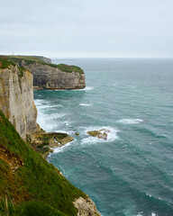 Vertical view of Etretat cliffs and turquoise Atlantic waves