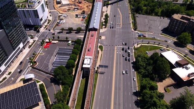 Skyscrapers, busy highway and subway station. The camera moves along the subway line crossing the highway.
