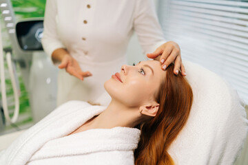 Unrecognizable beautician reassuring female patient before starting beauty or wellness treatment in...