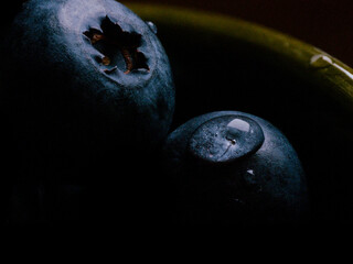 Extreme close-up macro shot of two blueberries in a bowl. Natural healthy food concept