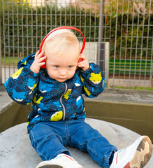 A young child wearing headphones and a blue jacket