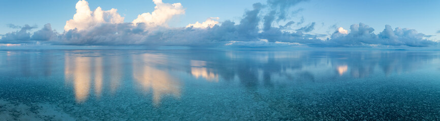 Evening light illuminates clouds drifting over Wakatobi National Park, off the coast of Sulawesi. This area is a popular destination for divers and snorkelers due to its high marine biodiversity.
