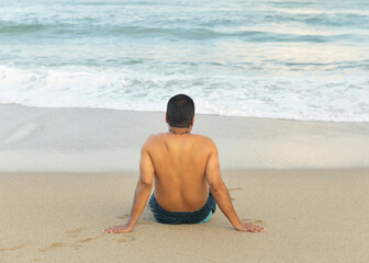 Yung latin man enjoys the panoramic view to the blue sea during summer vacation time.Relaxing...