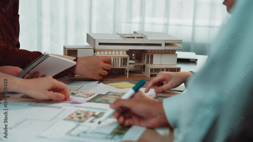 Poster a diverse team engages in a collaborative architectural design session, surrounded by models and ske