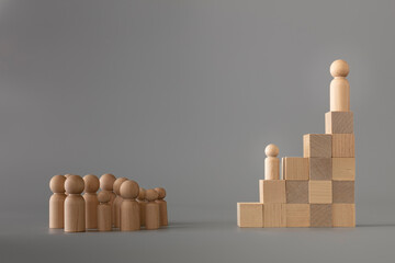 Leader figure standing out from crowd on wooden cubes, other in front on floor, one of them change....