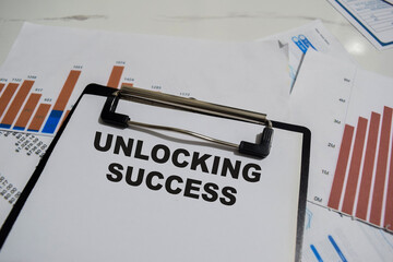 Concept of Unlocking Success write on paperwork isolated on Wooden Table.