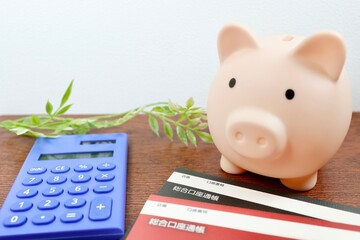 貯金と家計管理のイメージ　豚の貯金箱と通帳と電卓