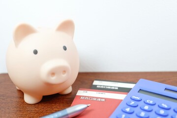 貯金と家計管理のイメージ　豚の貯金箱と通帳と電卓
